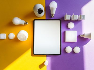 Top view of smart home devices and tablet on split yellow and purple background.
