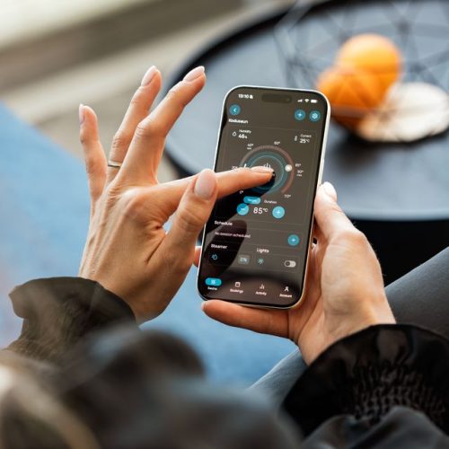 A woman interacts with a mobile sauna control app in a modern setting, adjusting the sauna settings.